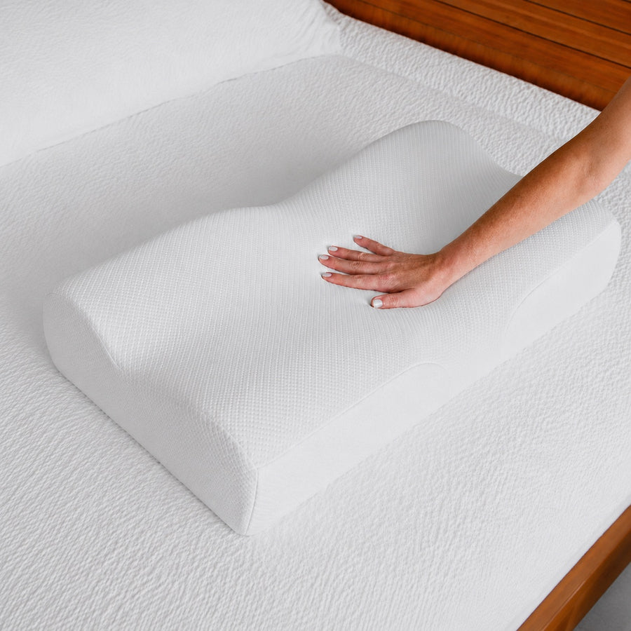 Main qui presse l'oreiller cervical NOCTENE, densite de la mousse